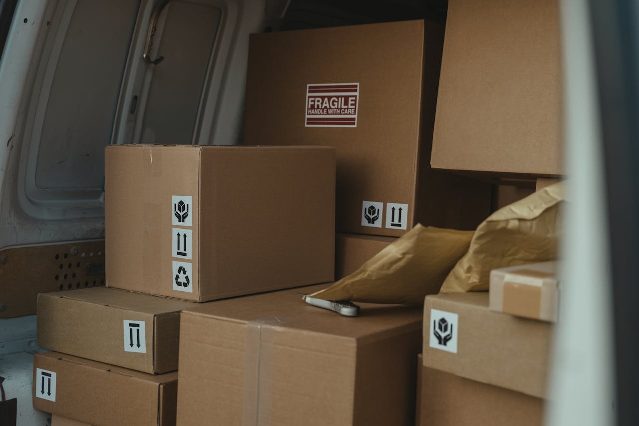 Inicio Neatly organized cardboard boxes inside a delivery van, ready for shipment.